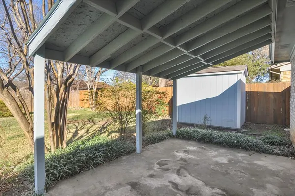 a backyard of a house with large trees and plants
