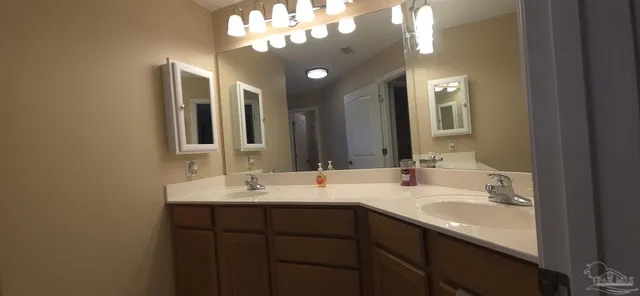a bathroom with a double vanity sink and a mirror