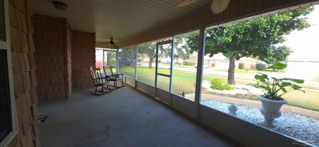 a view of a porch with chairs and backyard