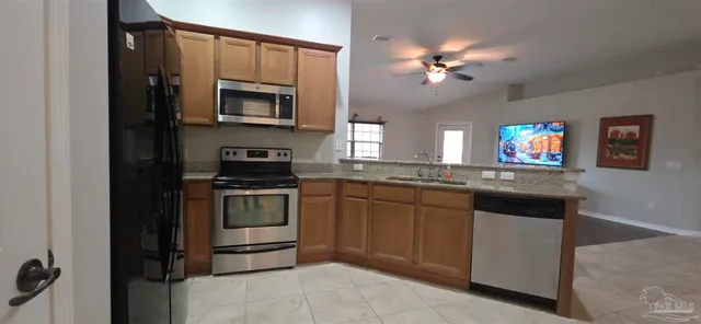 a kitchen with a refrigerator and a stove top oven