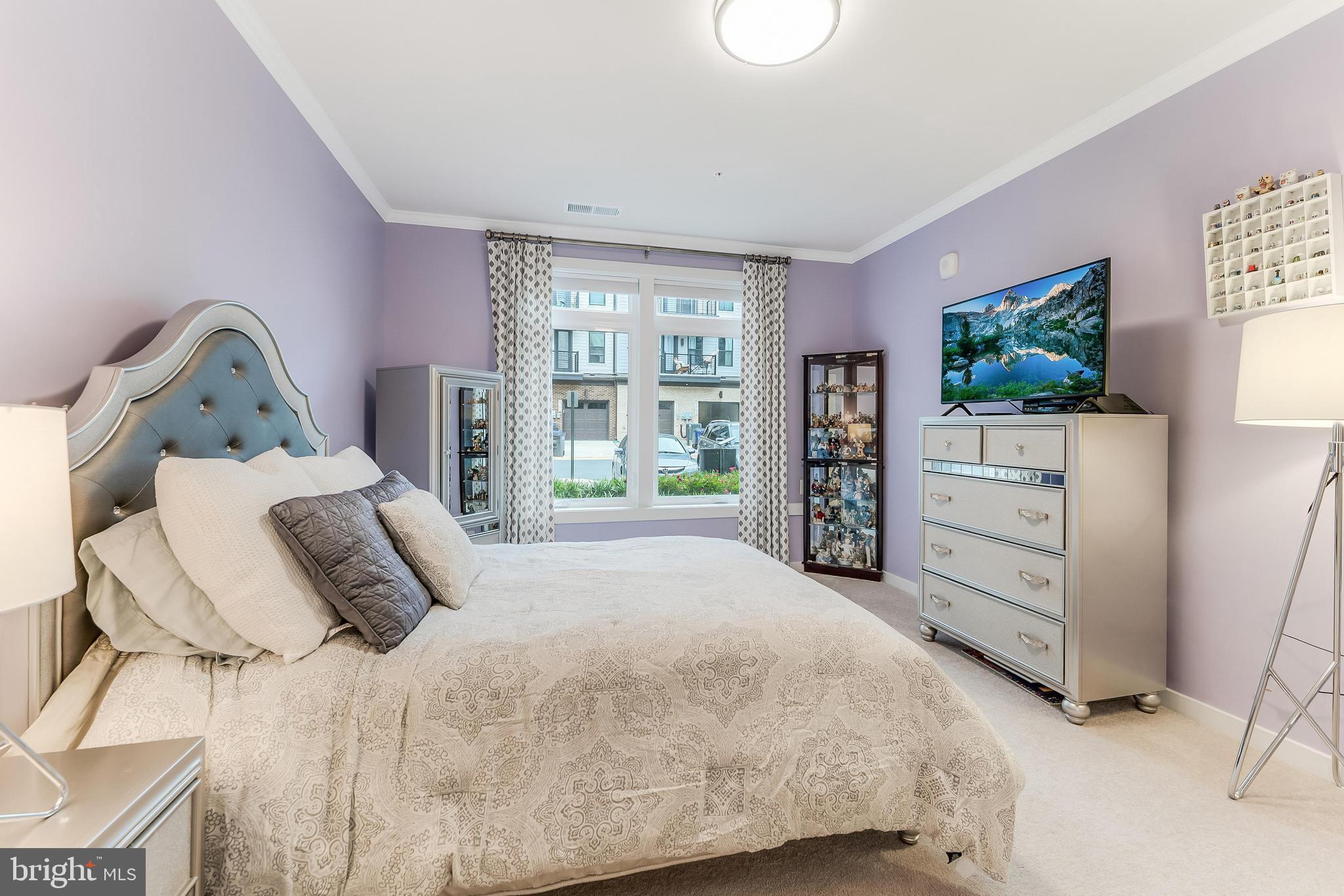 1675 Bandit Loop, Unit 105B Reston, VA 20190 - Photo 19 of 27 a bedroom with a bed and a flat tv screen in it