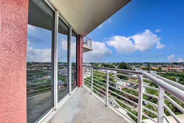 a view of a balcony with a floor to ceiling window and wooden fence