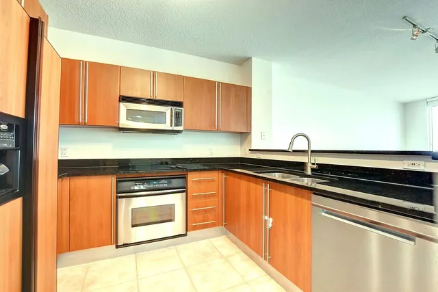 a kitchen with stainless steel appliances granite countertop a sink and a microwave