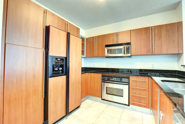 a kitchen with stainless steel appliances granite countertop a stove a microwave and a refrigerator