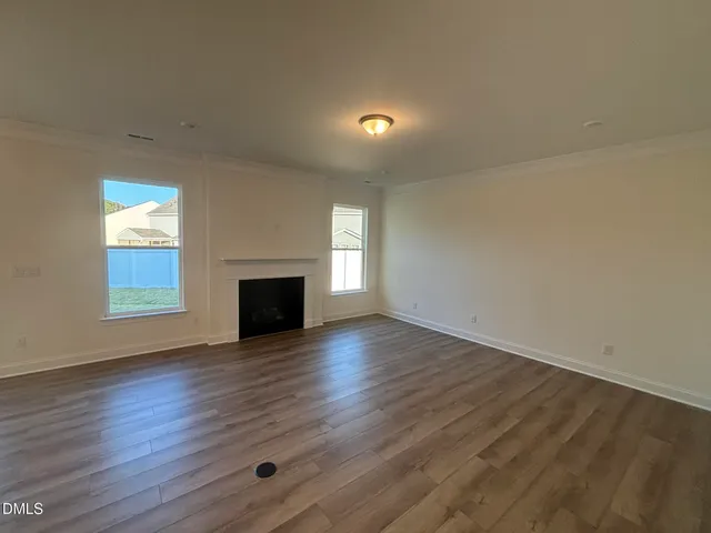 an empty room with wooden floor and fireplace