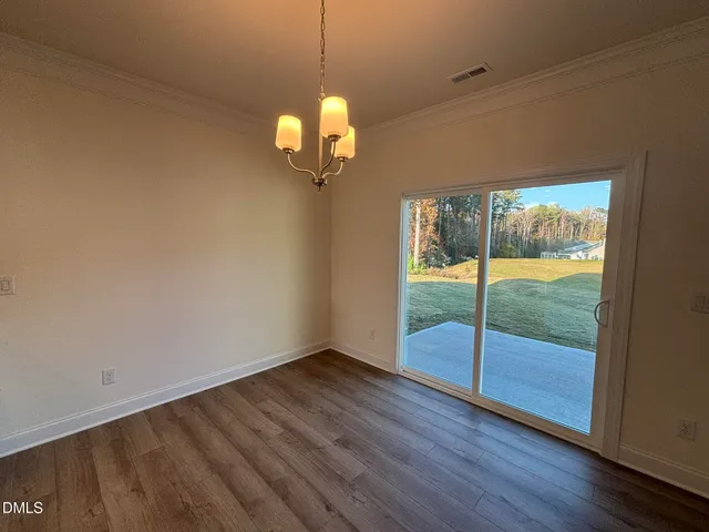an empty room with wooden floor and city view