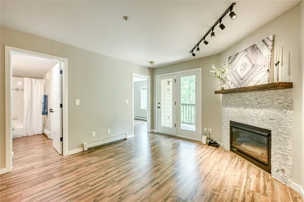 wooden floor fireplace and windows in an empty room