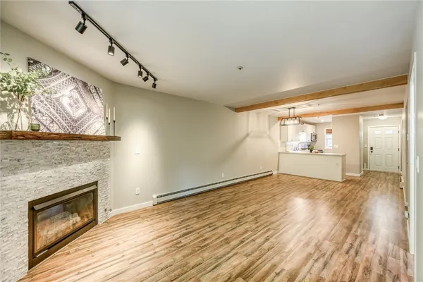 a view of empty room with wooden floor and fireplace
