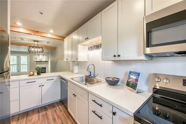 a kitchen with sink a microwave and cabinets