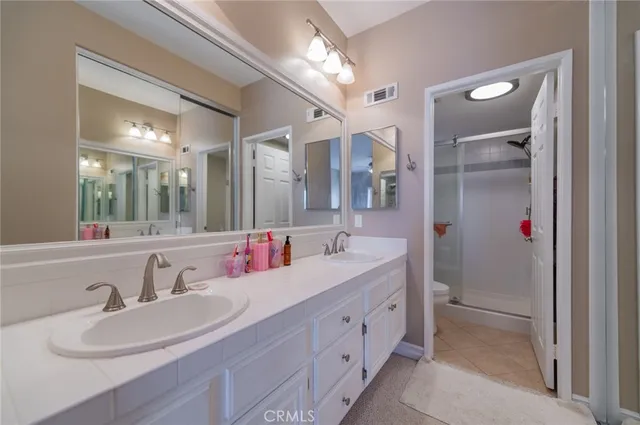 a spacious bathroom with a double vanity sink mirror and toilet