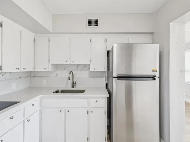 a kitchen with a refrigerator and cabinets