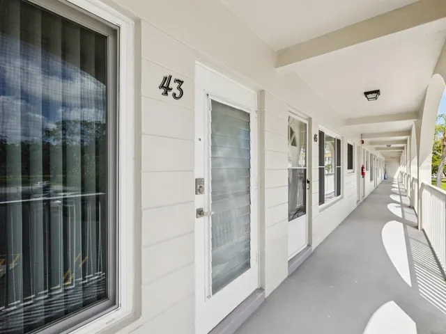 a view of a hallway with wooden floor and windows