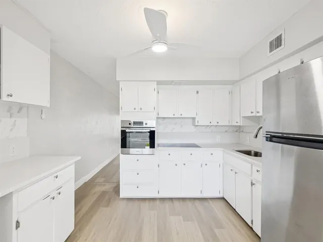 a kitchen with cabinets appliances and a counter space