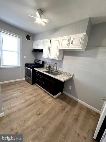 a kitchen with a stove sink and cabinets
