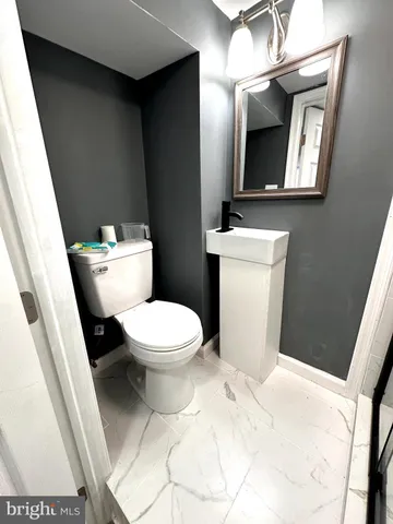 a white toilet sitting next to a bathroom sink