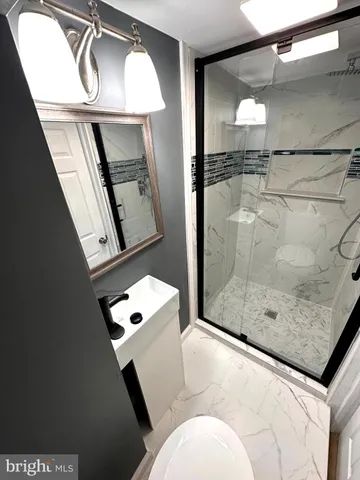 a bathroom with a shower a mirror and vanity