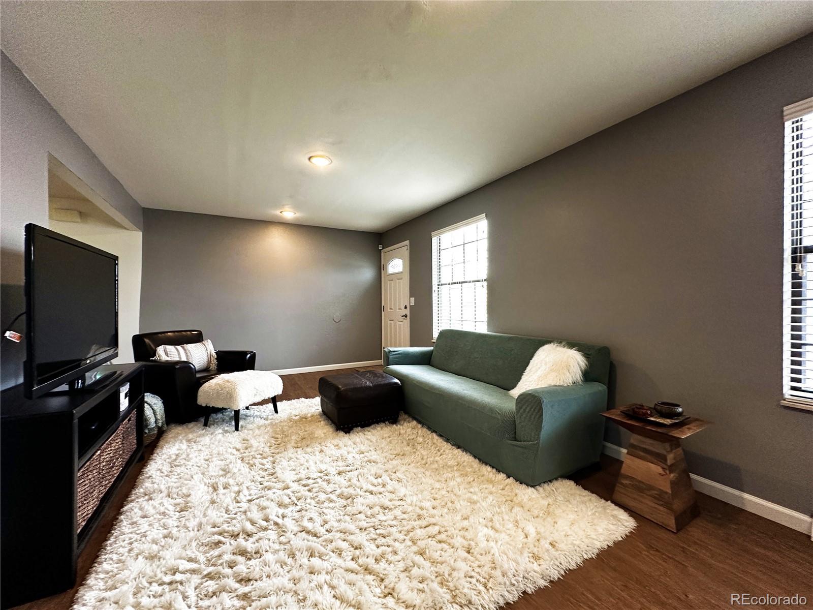 10753 Routt Court Broomfield, CO 80021 - Photo 2 of 24 a living room with furniture and a flat screen tv