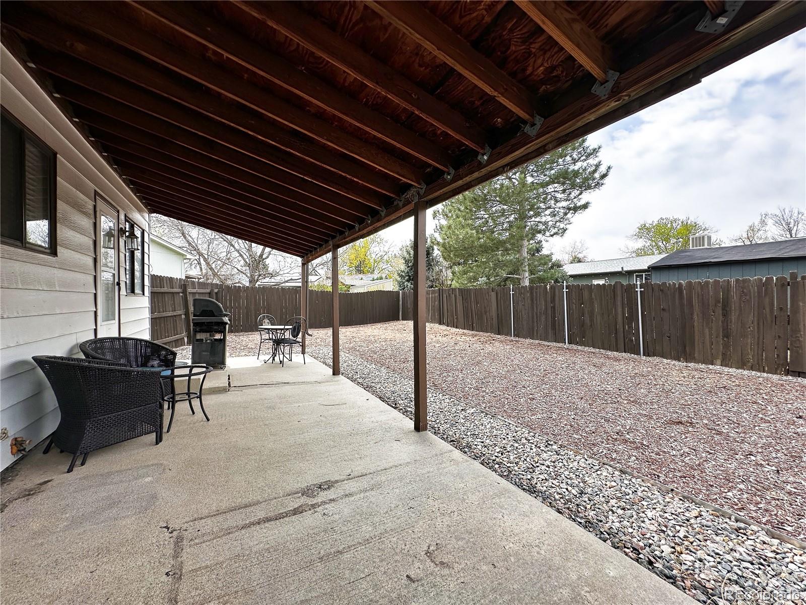10753 Routt Court Broomfield, CO 80021 - Photo 22 of 24 a view of backyard with table and chairs with wooden fence