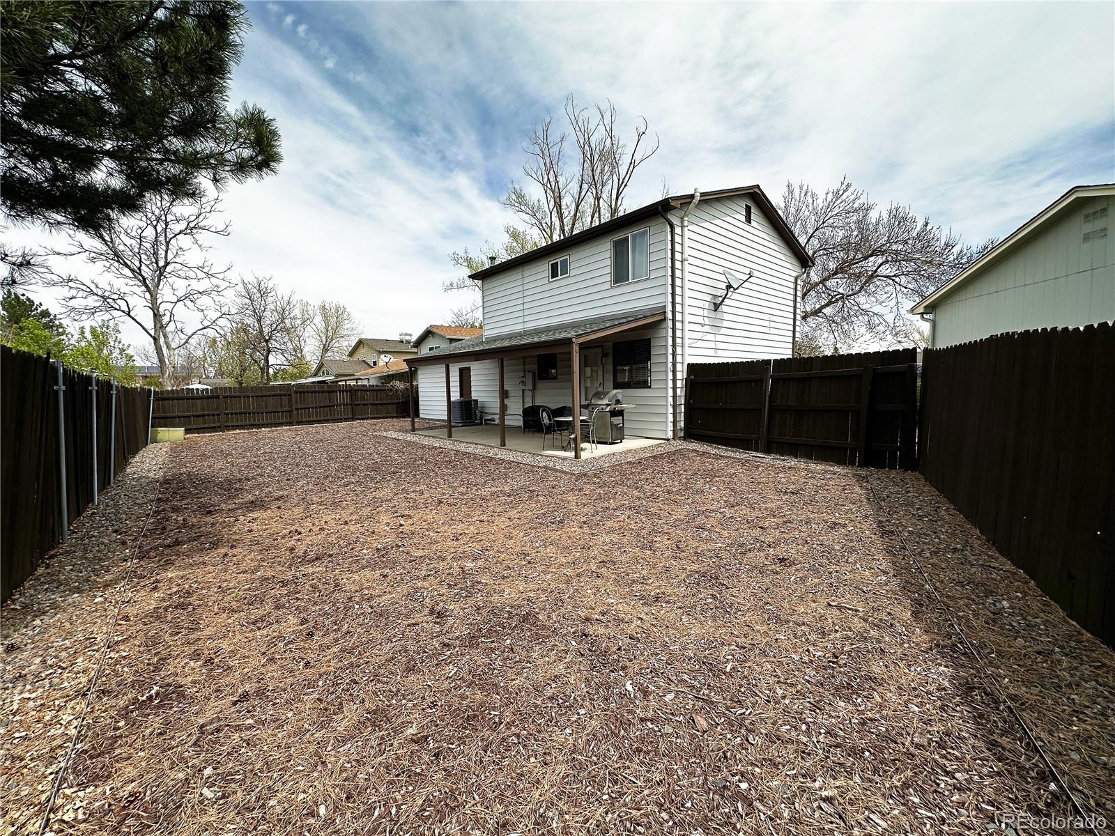 10753 Routt Court Broomfield, CO 80021 - Photo 24 of 24 a backyard of a house with table and chairs with wooden fence