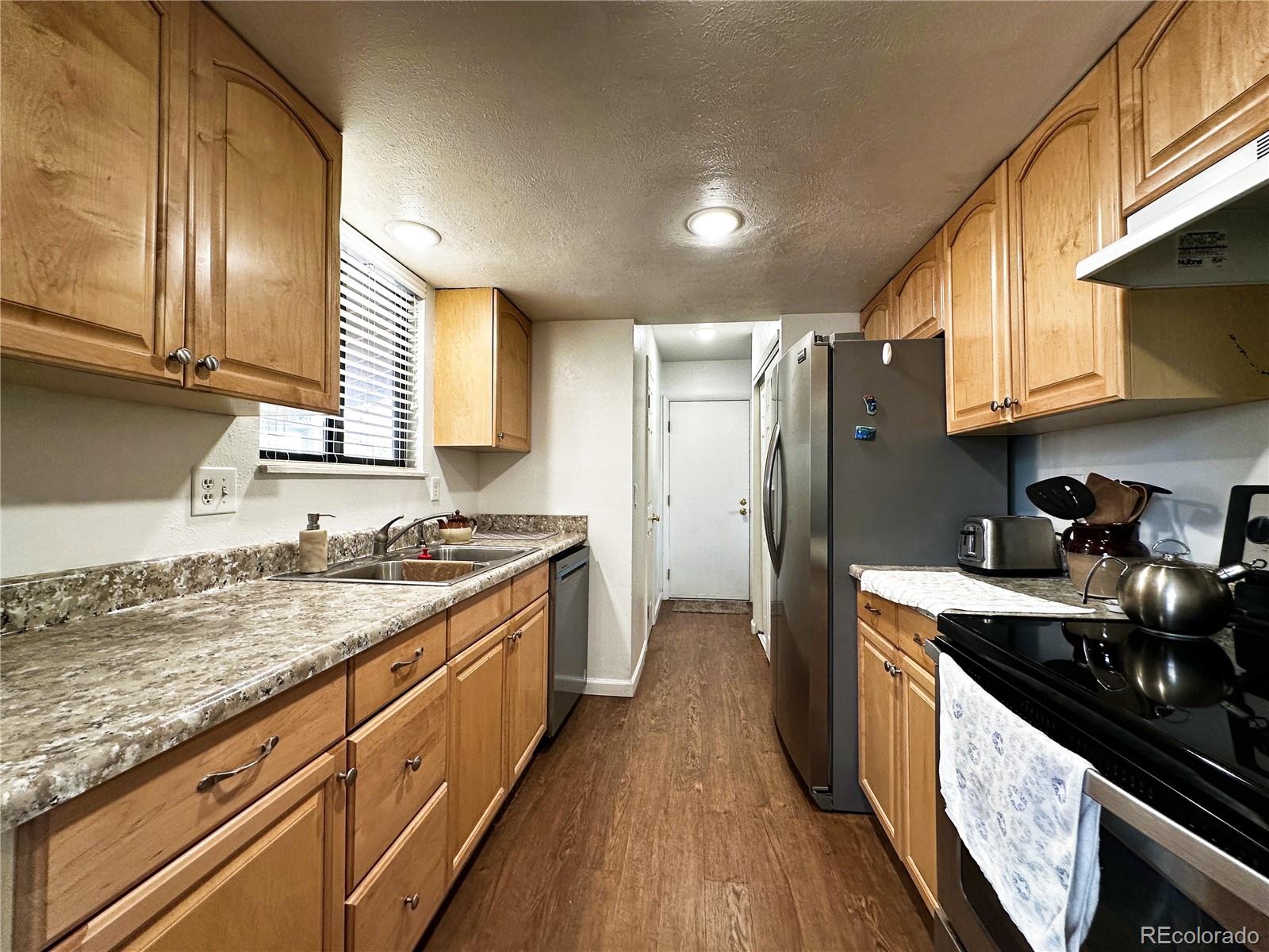 10753 Routt Court Broomfield, CO 80021 - Photo 7 of 24 a kitchen with granite countertop a sink stove and refrigerator
