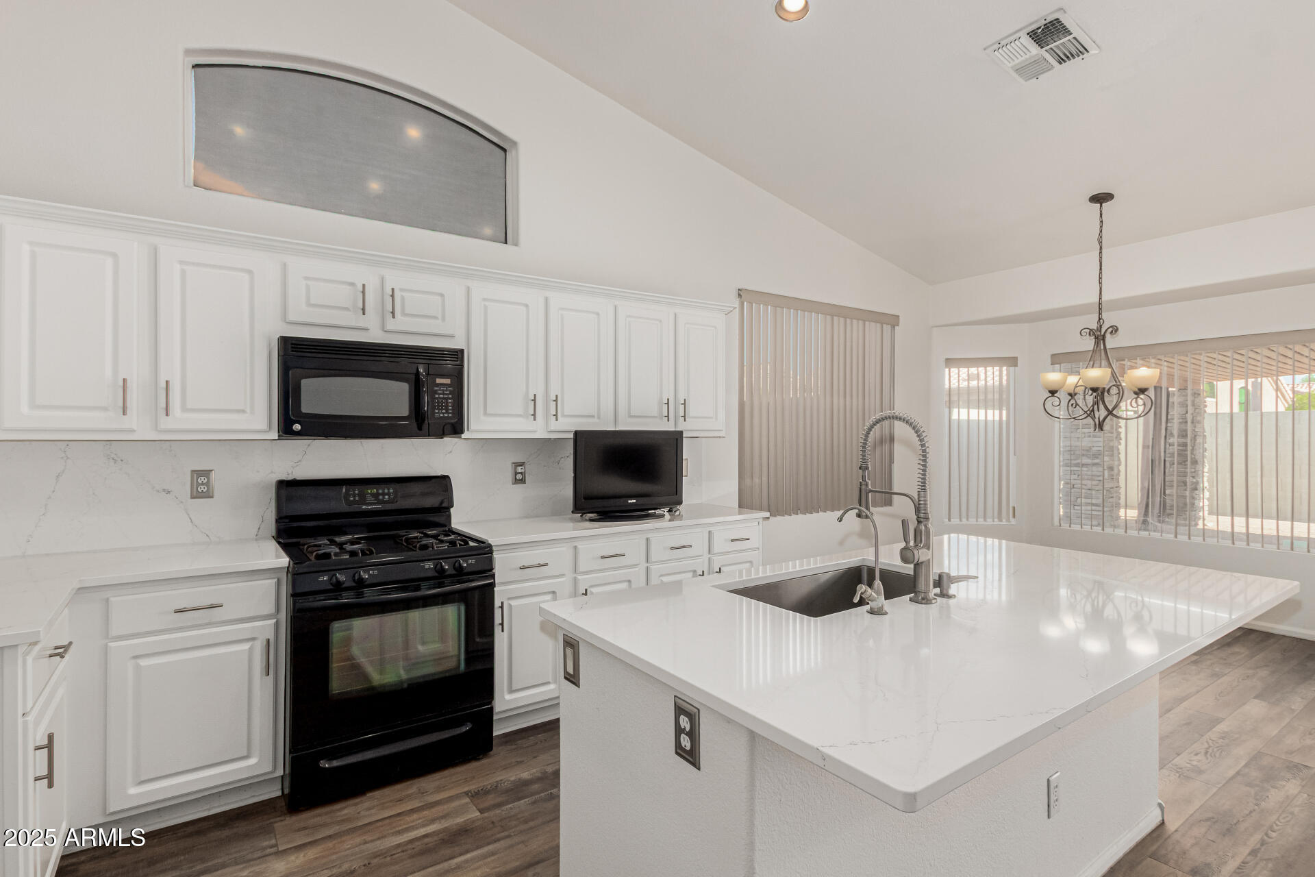 217 West Smoke Tree Road Gilbert, AZ 85233 - Photo 4 of 48 a kitchen with granite countertop a sink and a stove top oven with wooden floor