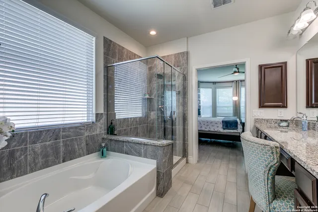 a bathroom with a tub a sink and a large mirror