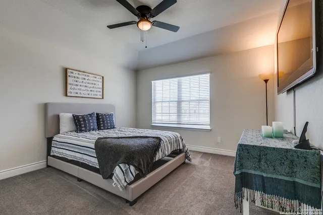 a spacious bedroom with a bed a couch and a chandelier