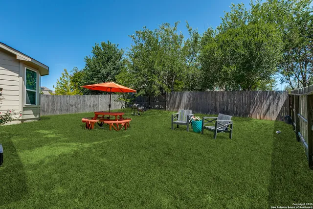 a view of backyard with a slide and swing