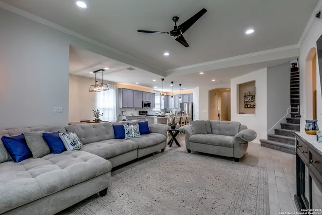 a living room with furniture and a ceiling fan