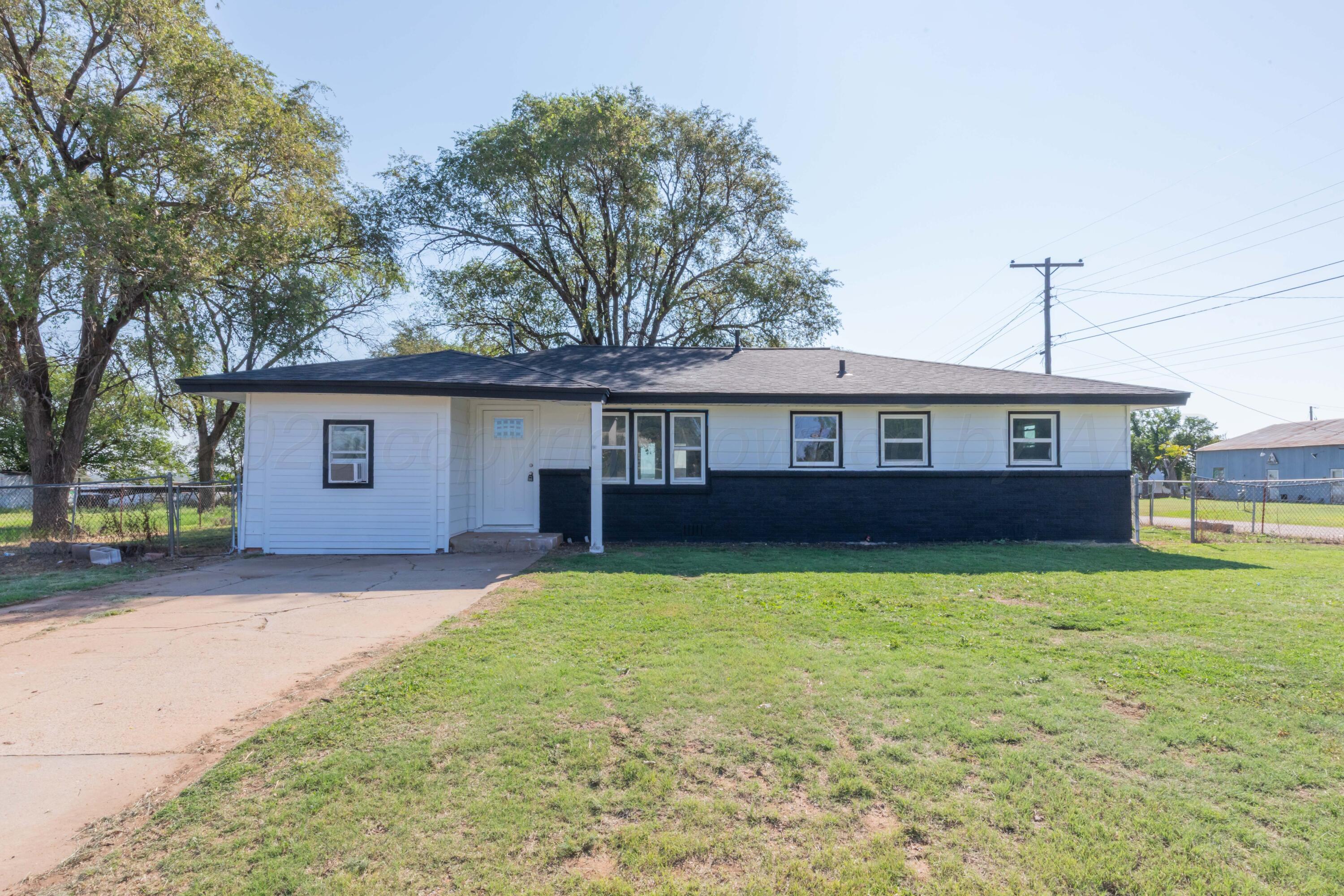 a front view of house with yard and trees in the background