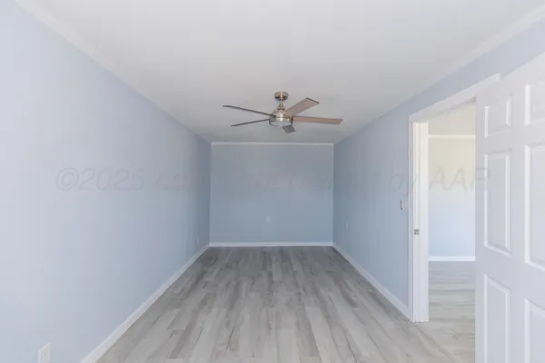 a view of a room with wooden floor fan and windows