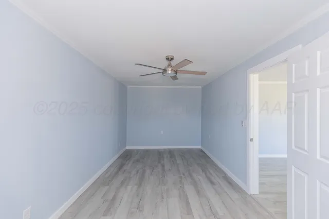 a view of a room with wooden floor fan and windows