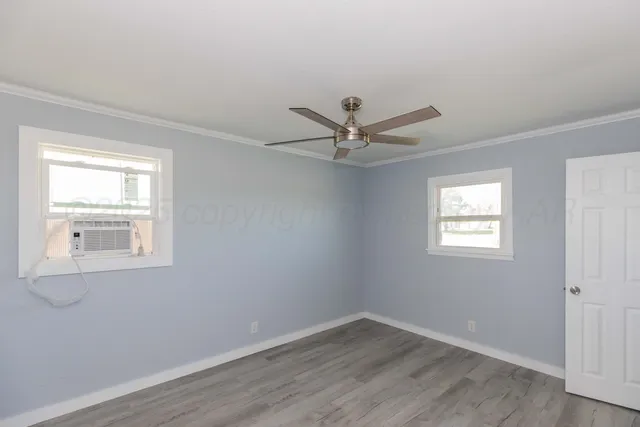 a view of a big room with wooden floor and windows