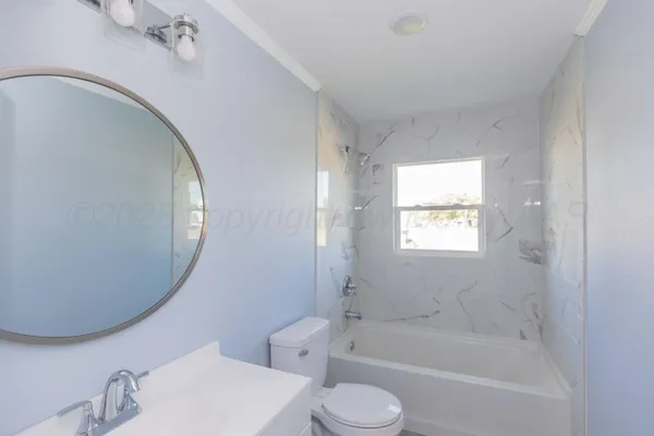 a bathroom with a bathtub sink vanity mirror and toilet