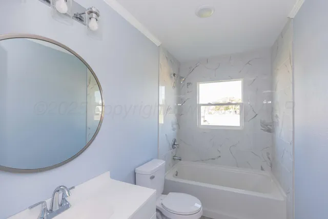 a bathroom with a bathtub sink vanity mirror and toilet