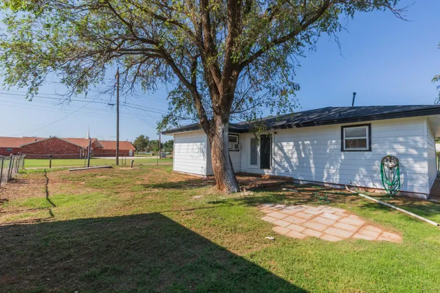 a view of a house with backyard and sitting area