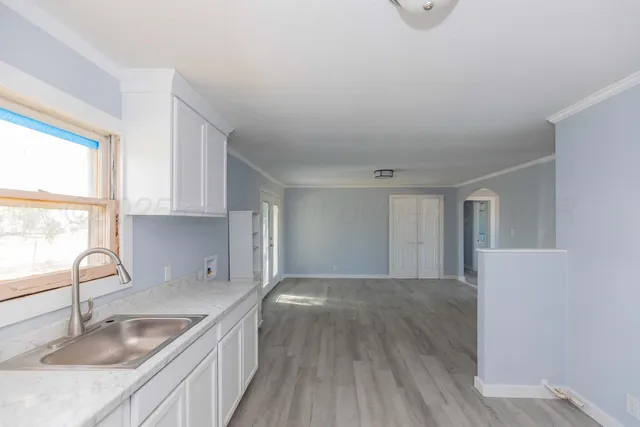 a kitchen with granite countertop a sink a stove and cabinets