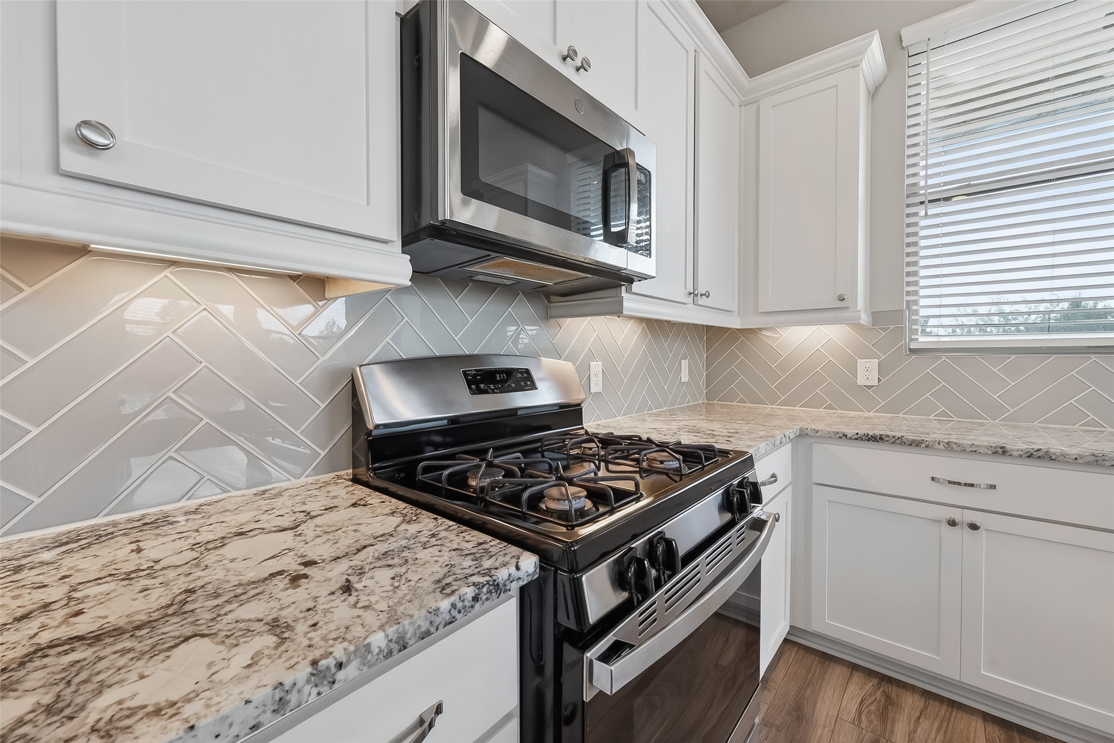 16226 Rattlesnake Run Trail Cypress, TX 77433 - Photo 9 of 29 a kitchen with stainless steel appliances granite countertop a stove and a microwave
