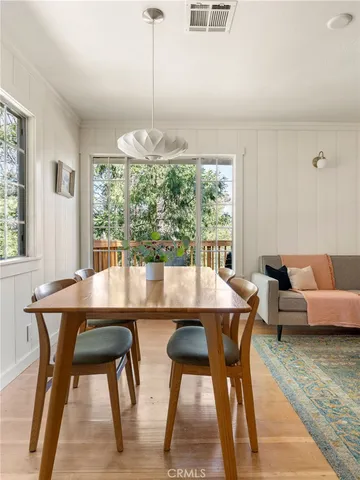a dining room with furniture a chandelier and wooden floor