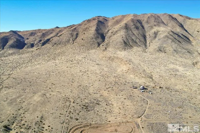 a view of a dry space with mountains in the background