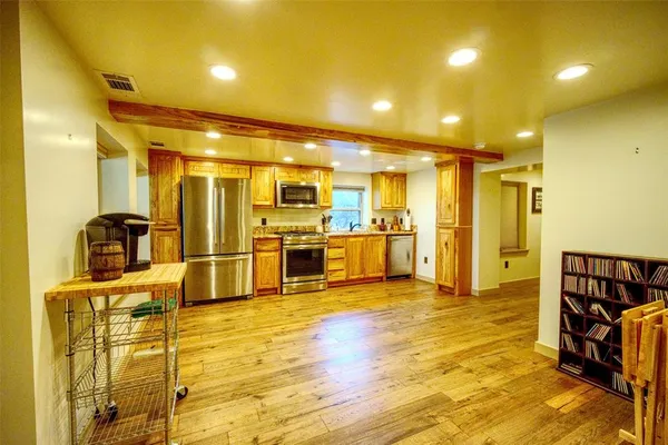 a view of a kitchen with refrigerator and chairs