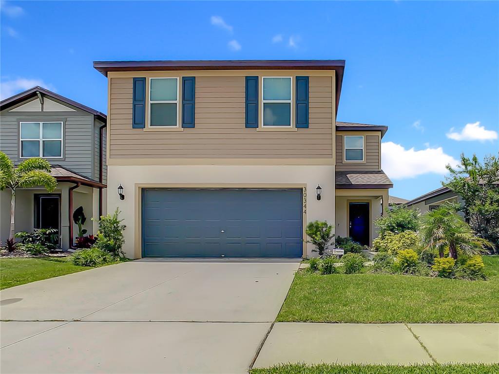 30344 Marquette Avenue Wesley Chapel, FL 33545 - Photo 1 of 71 a front view of a house with a garden and entryway
