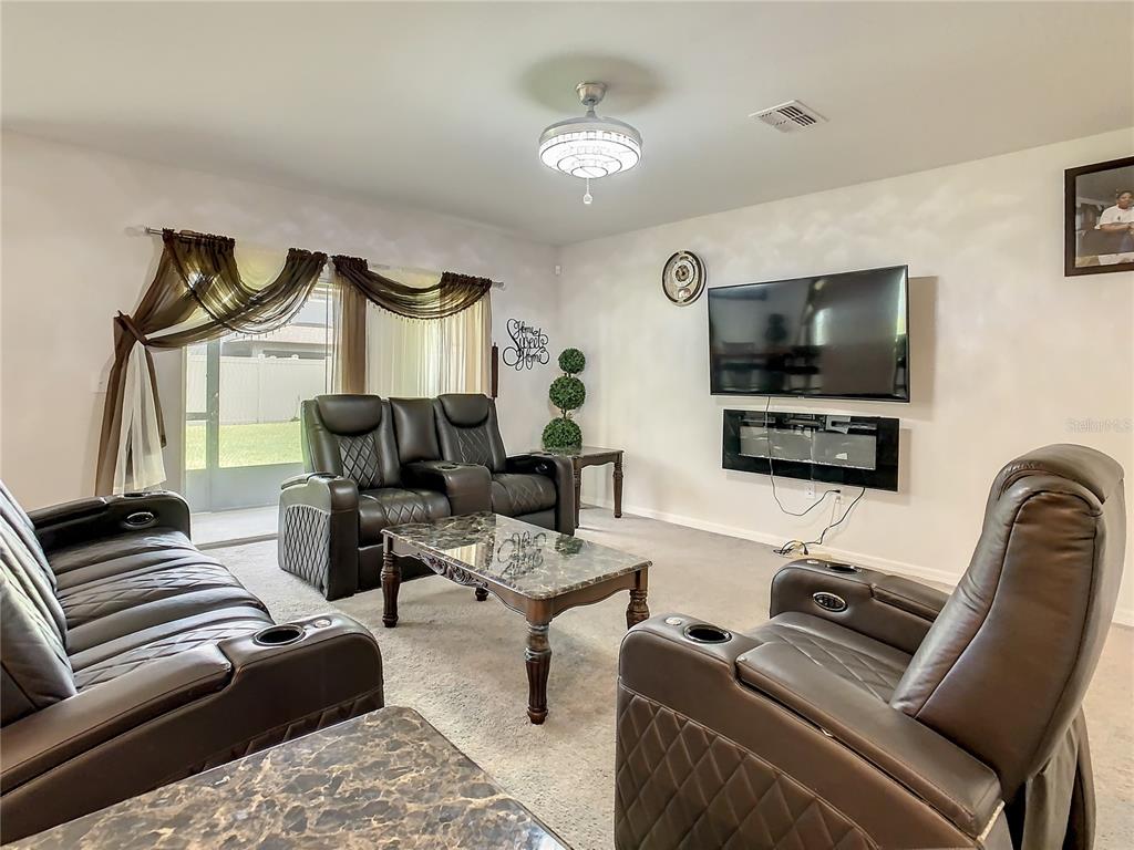 30344 Marquette Avenue Wesley Chapel, FL 33545 - Photo 18 of 71 a living room with furniture a flat screen tv and kitchen view