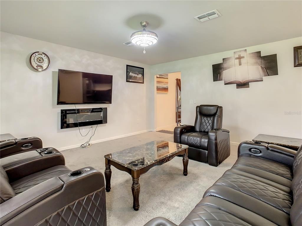30344 Marquette Avenue Wesley Chapel, FL 33545 - Photo 19 of 71 a living room with furniture and a flat screen tv