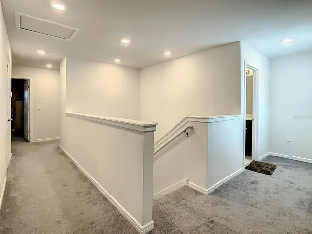 a bedroom with a bed and a lamp on dresser