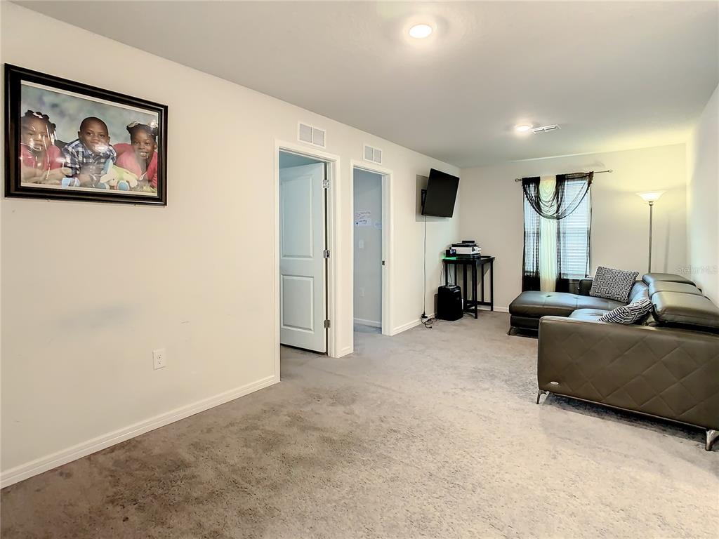 30344 Marquette Avenue Wesley Chapel, FL 33545 - Photo 21 of 71 a living room with furniture and a flat screen tv