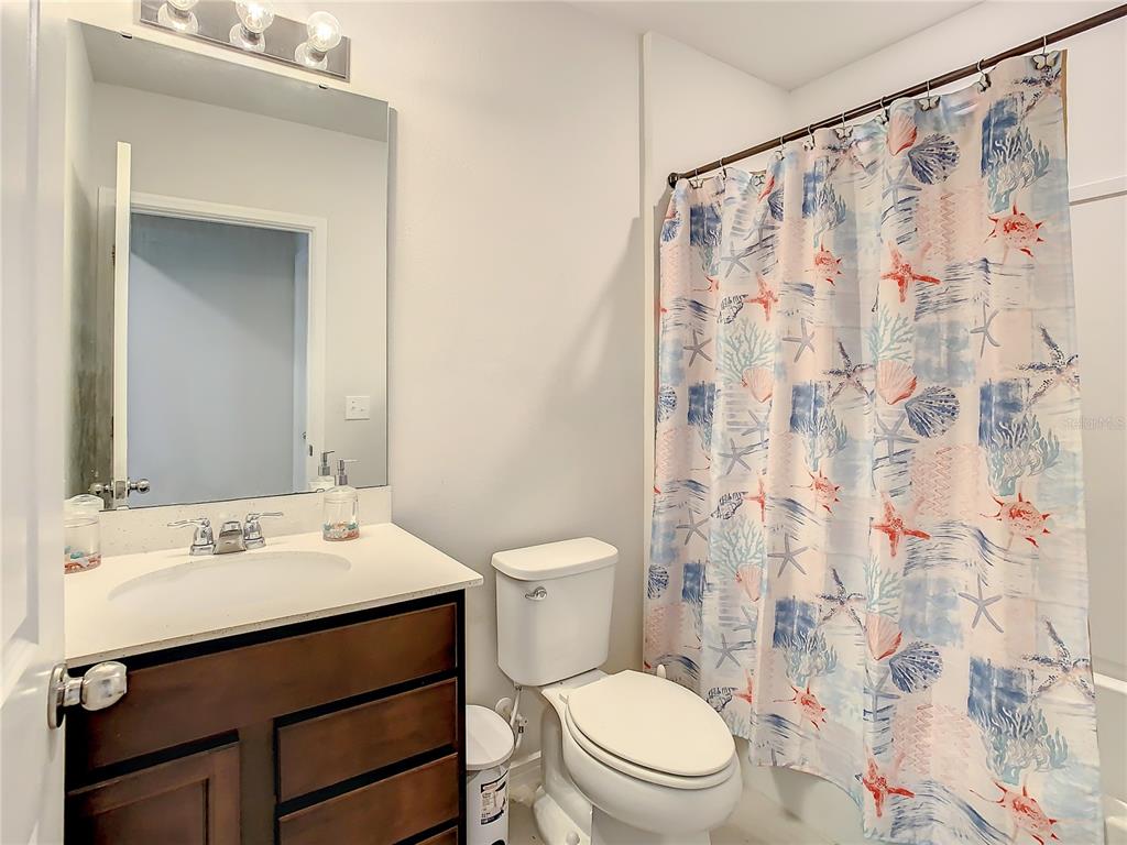 30344 Marquette Avenue Wesley Chapel, FL 33545 - Photo 31 of 71 a bathroom with a sink a toilet and shower curtain