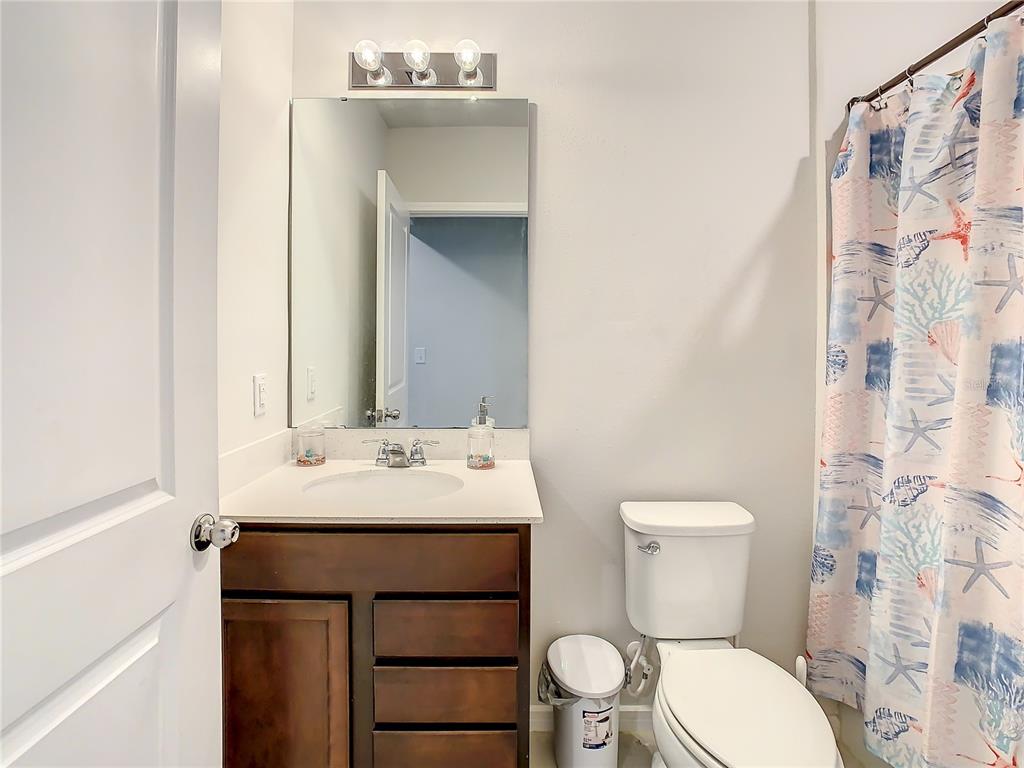 30344 Marquette Avenue Wesley Chapel, FL 33545 - Photo 32 of 71 a bathroom with a sink a toilet and shower curtain