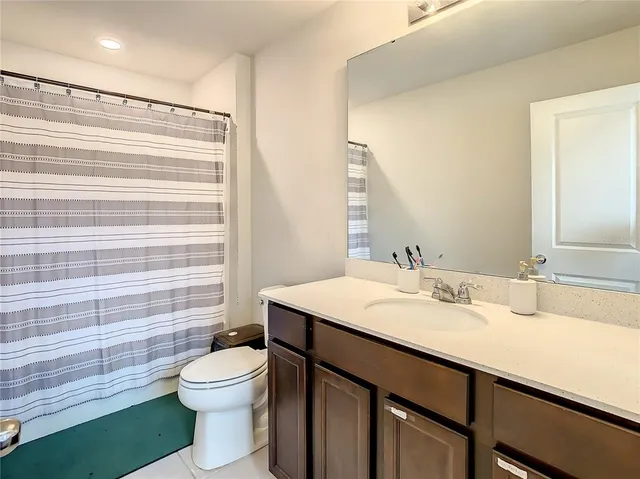 a bathroom with a toilet and a shower curtain
