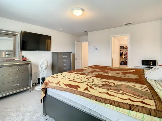 a large bed sitting in a bedroom next to a lamp